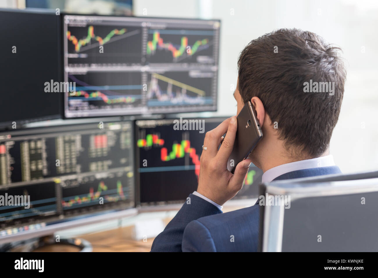 Broker Computer Screen Over the shoulder view of computer screens and stock broker trading ...