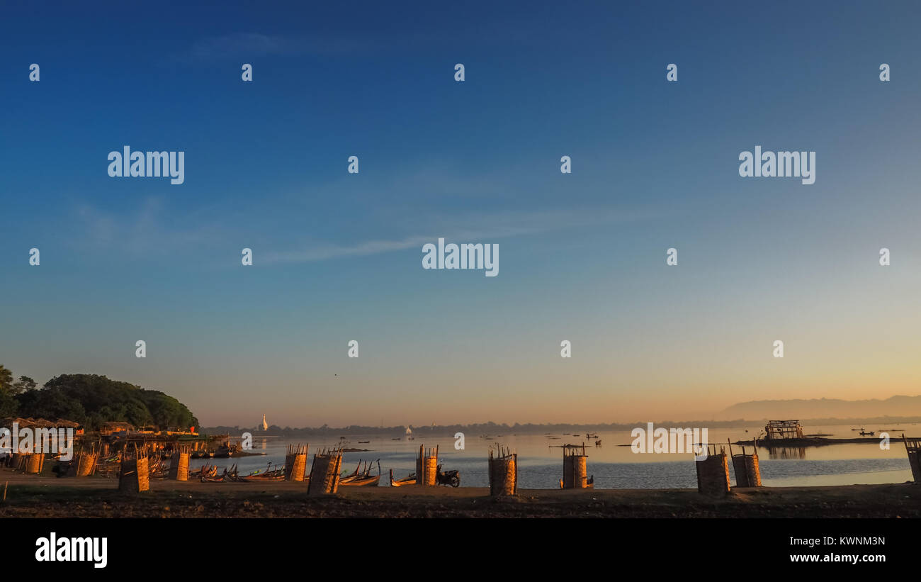 Sunset in U Bein bridge with vintage boat Myanmar Stock Photo - Alamy