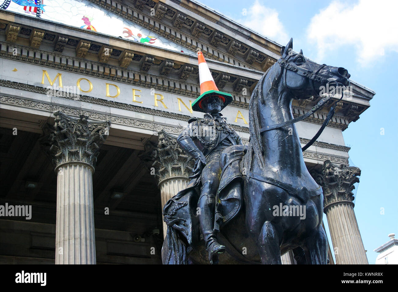 Famous equestrian statue of the Duke of Wellington with a road cone on his head,  in front of the Gallery of Modern Art in Glasgow, Scotland. Stock Photo
