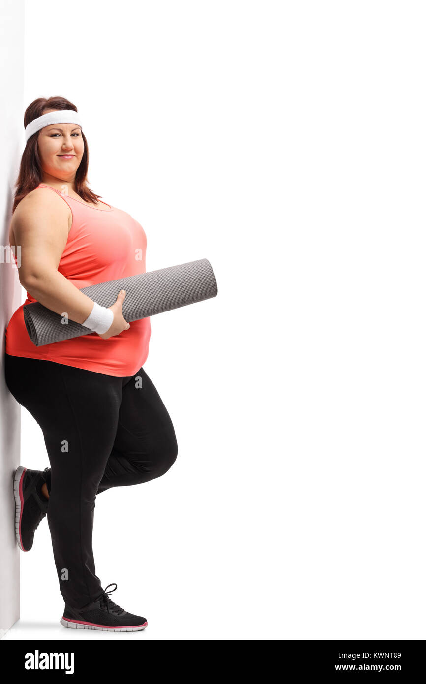 Full length portrait of an overweight woman with an exercise mat