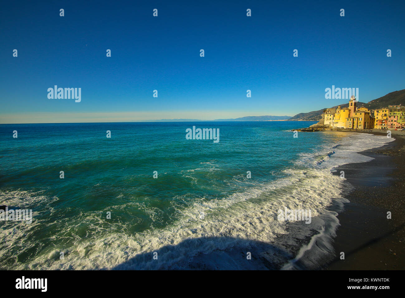 Camogli, Italy - People relaxing on the beach and the basilica Santa Maria Assunta in the background Stock Photo