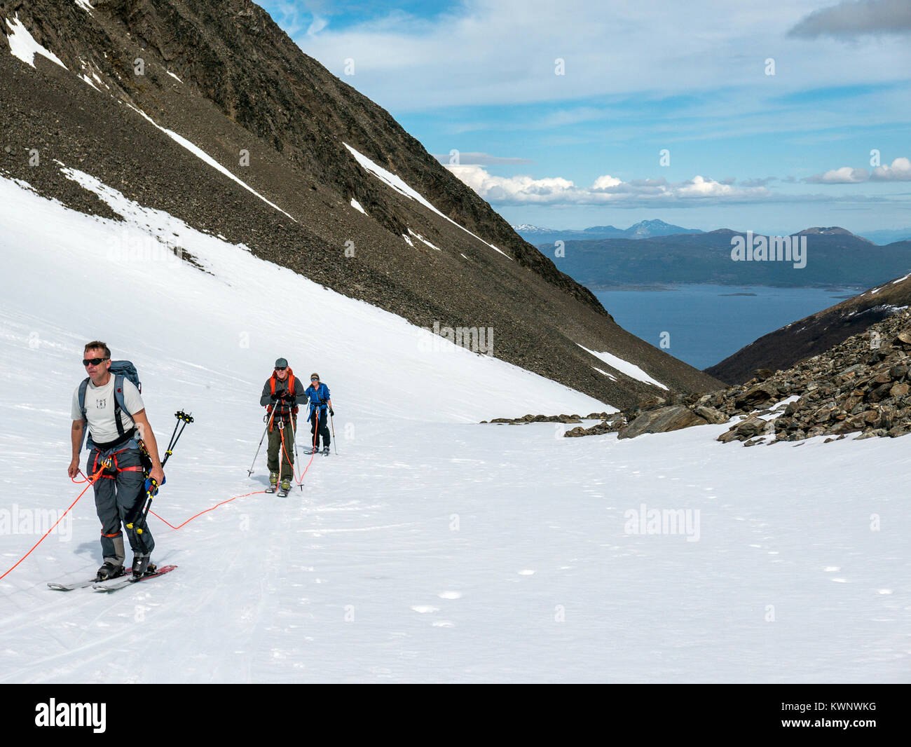 Backcountry alpine skiers climb on ski skins; roped for glacier crossings; Glaciar Martial; Mount Krund; Cerro Castor; near Ushuaia; Argentina Stock Photo