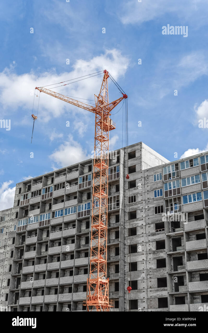 Building. Crane towering over the concrete structure. Stock Photo