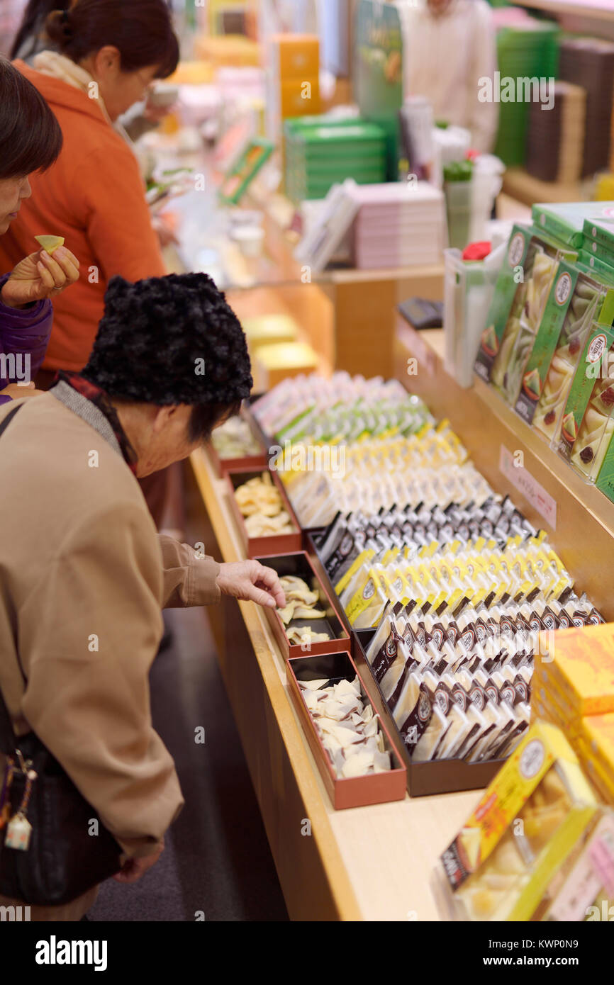 People sampling Japanese sweets, Yatsuhashi triangles at a souvenir confectionery store in Kyoto, Japan 2017 Stock Photo