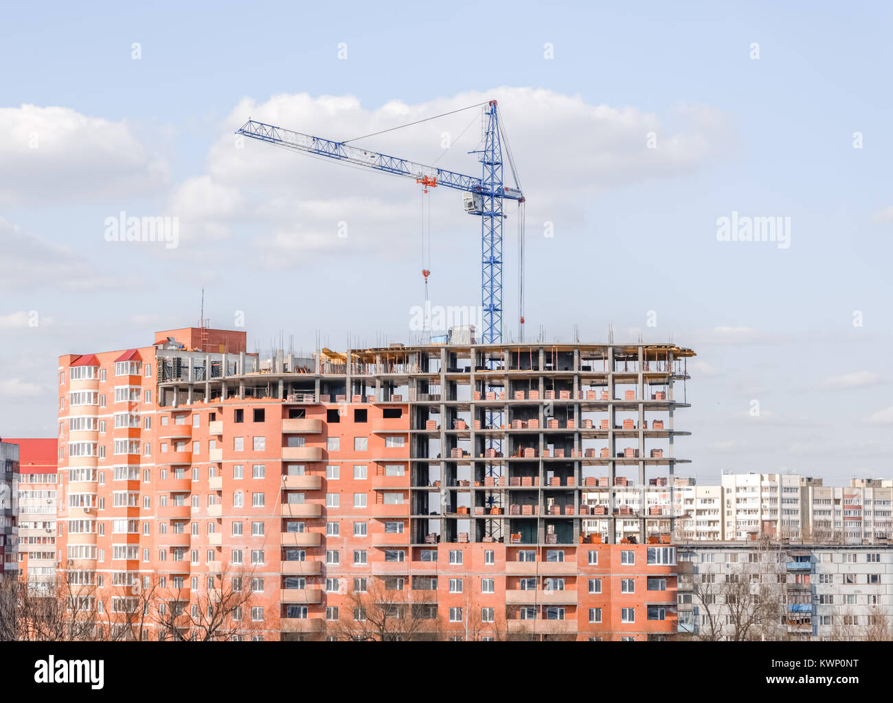 crane against a new block of flats, new multi-storey house. Stock Photo