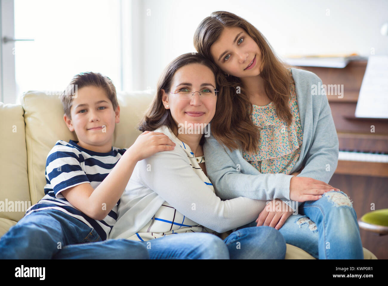 Portrait of pretty young mother with her two children adorable tennager daughter and son Stock Photo