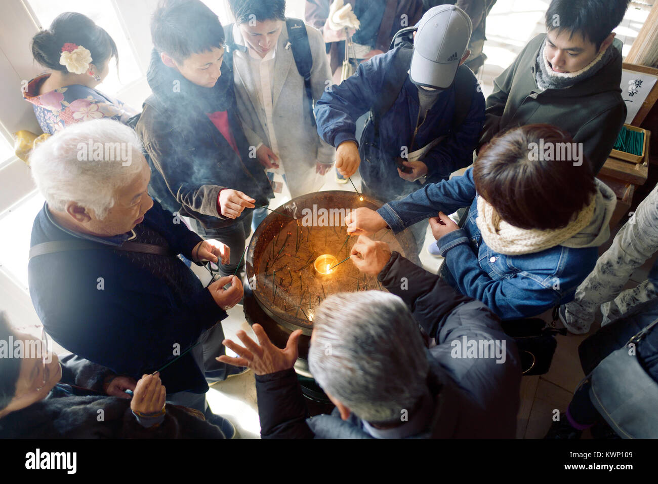 Overhead view of people lighting joss sticks in incense burner at Kiyomizu-dera Buddhist temple in fall. Higashiyama, Kyoto, Japan 2017. Stock Photo