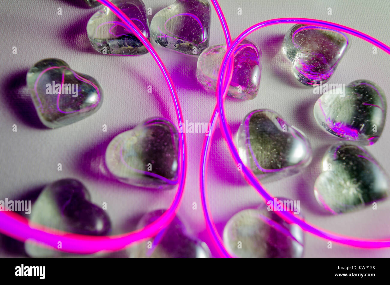 A Studio Photograph of Glass Hearts with Abstract Pink Neon Lighting Stock Photo