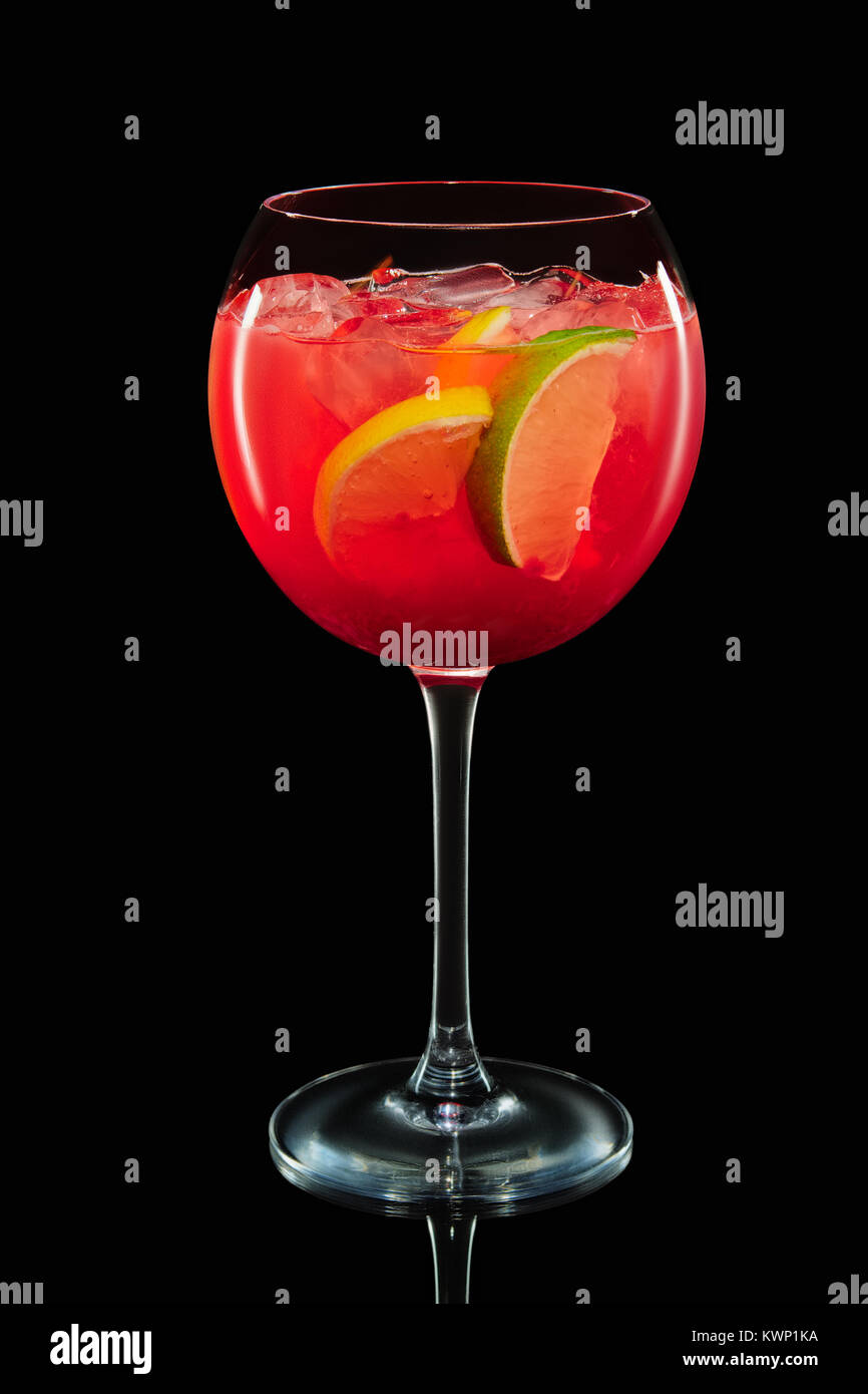 Big round wine glass with citrus sangria on black background with