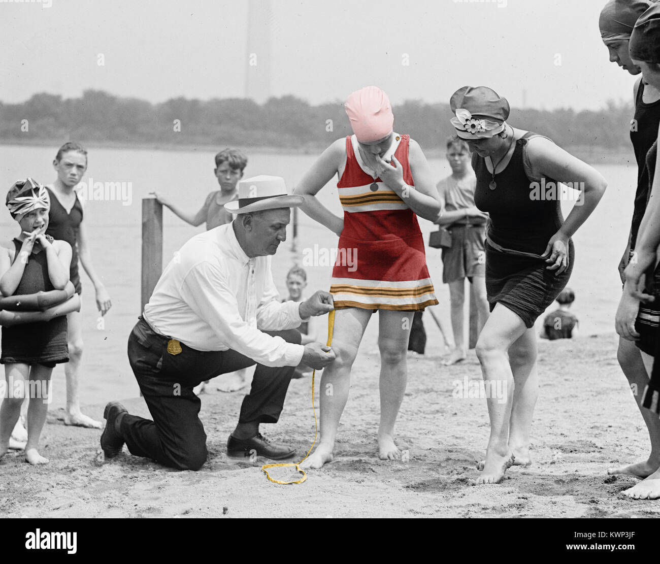 vintage photo of a Sheriff measuring the length of a young girls bathing suit circa 1922. Stock Photo