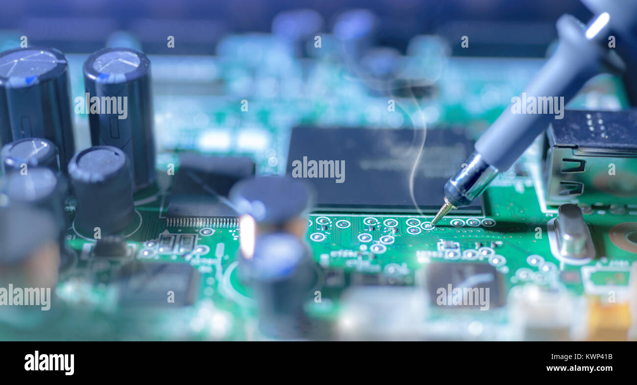 Electronic background: soldering of computer motherboard, shallow DOF ...