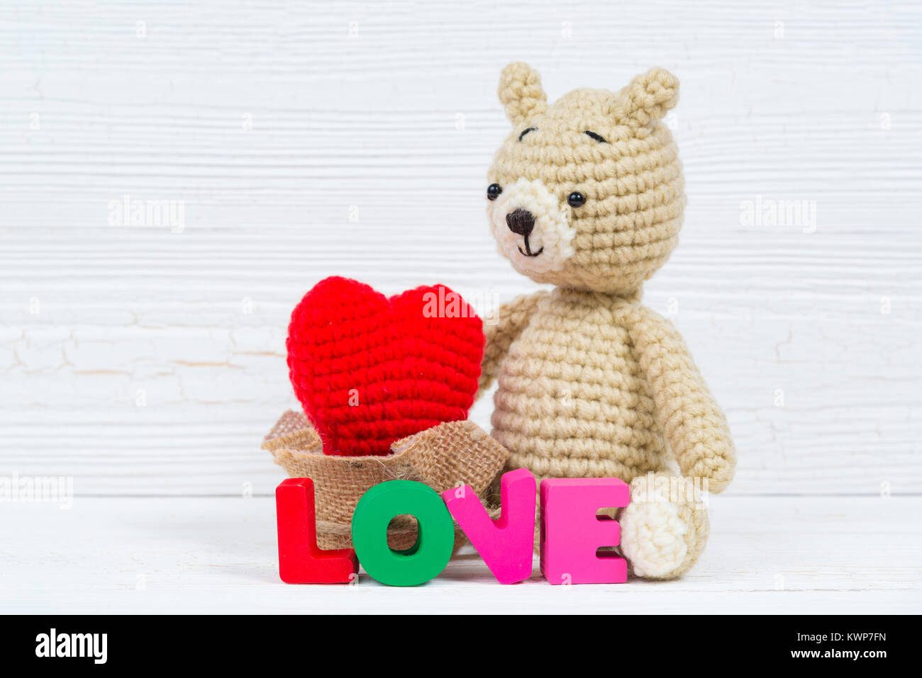 Sweet teddy bear doll with Love text and red knitting heart on white ...