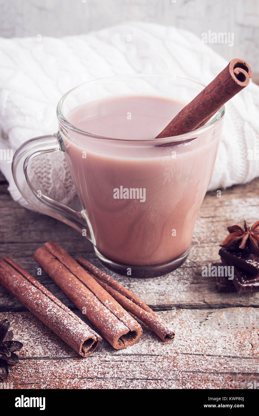 Hot cocoa with cinnamon sticks on white background. Image tinted Stock