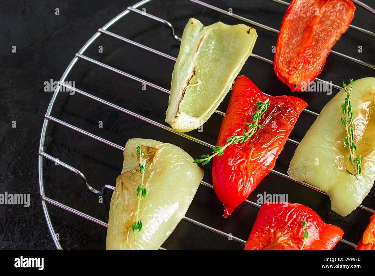 red and green peppers grilled on a black background Stock Photo - Alamy
