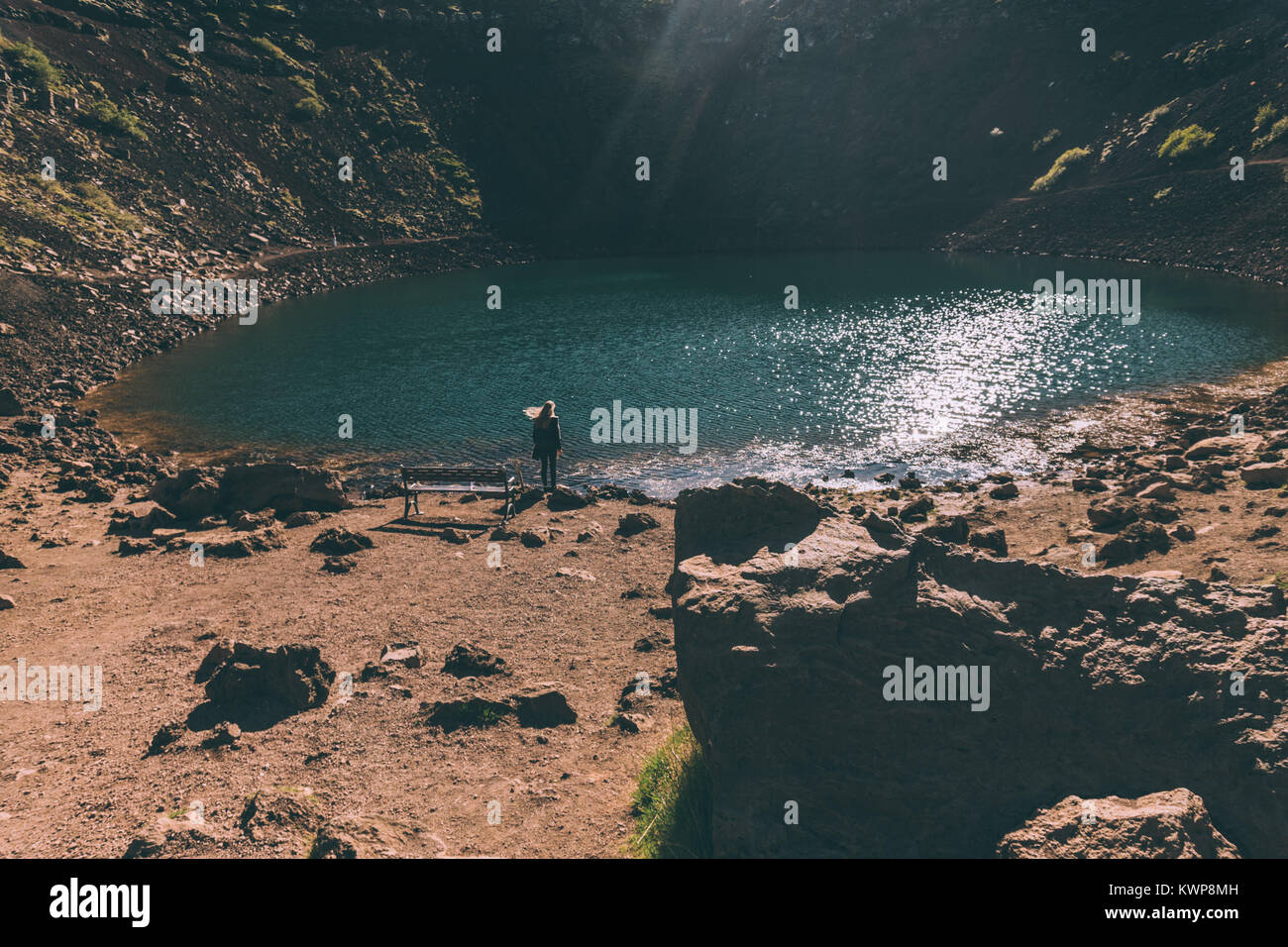 back view of young woman looking at beautiful scenic crater lake in Iceland Stock Photo