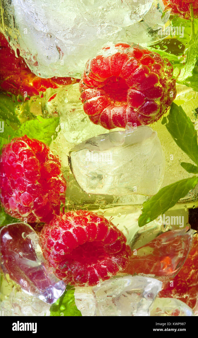 Yellow Raspberry Drinks Macro closeup of a yellow cocktail drink with raspberries and mint ...