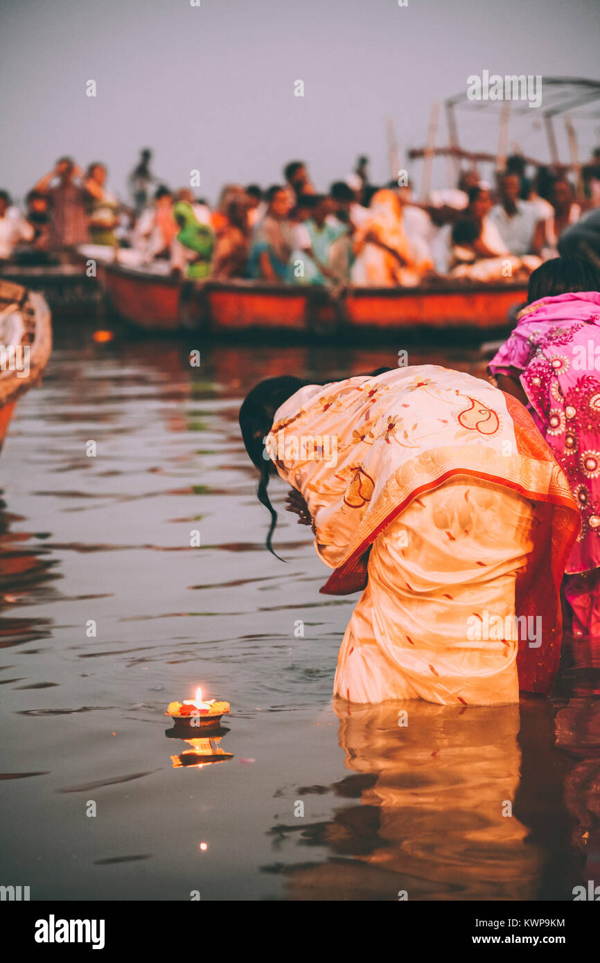 people perform ritual puja at dawn in the Ganges River in Varanasi, India Stock Photo