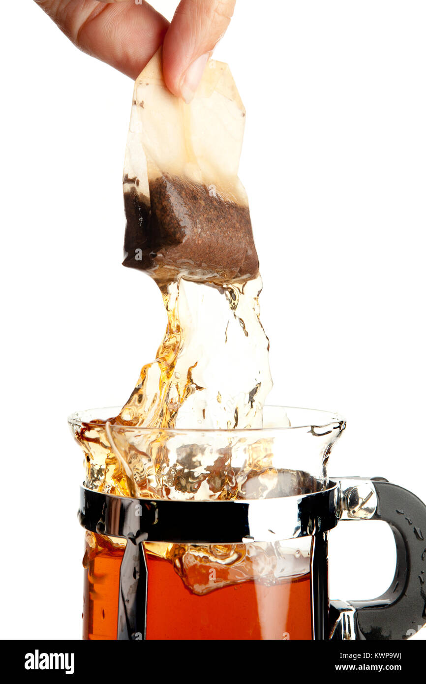 Hand removing a hot tea bag from a tea cup Stock Photo Alamy