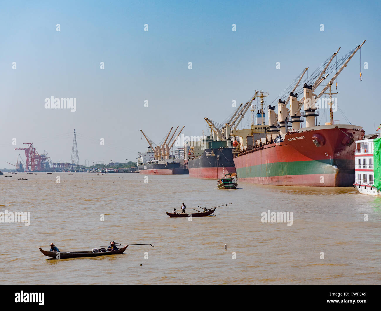 Small, traditional fishing boats catching fish on Yangon River next to one of Yangonâ€™s main commercial ports. Stock Photo