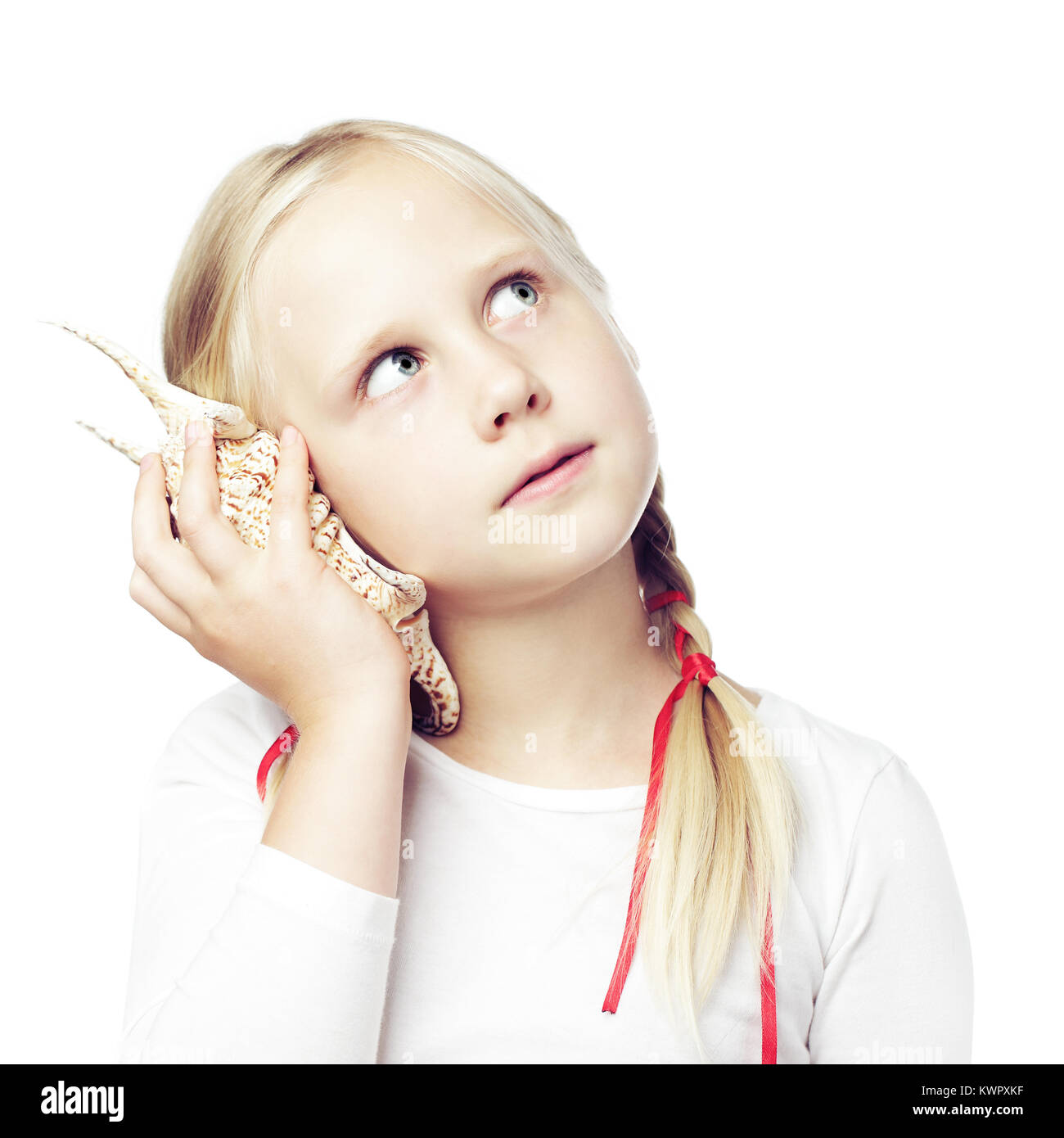 Child holding a shell to his ear, communication concept Stock Photo - Alamy