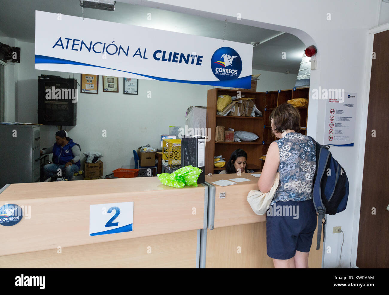 A woman at the counter in a post office, Puerto Ayora, Santa Cruz island, Galapagos islands, Ecuador South america Stock Photo