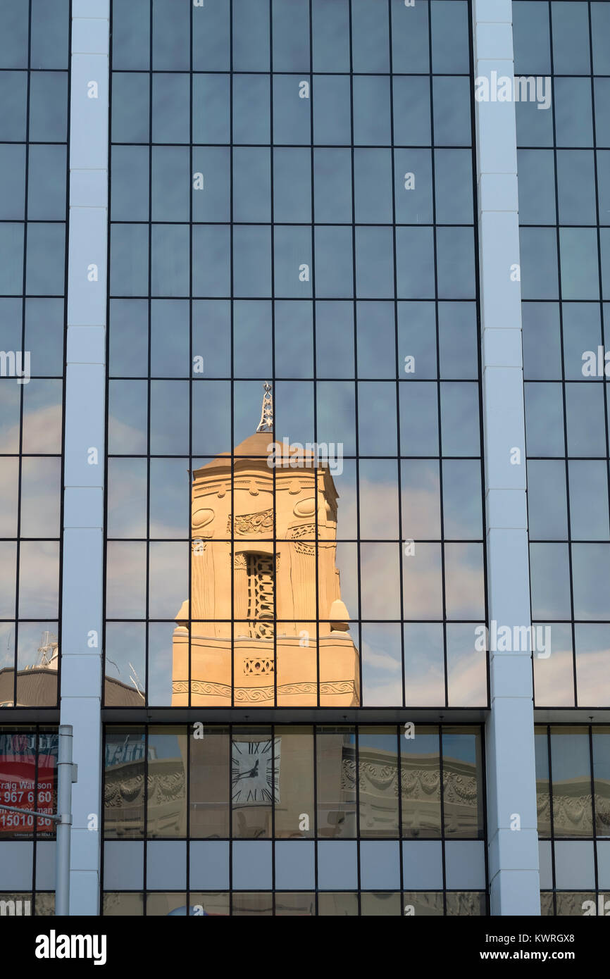 Auckland town hall reflected in the windows of a modern glass building in the city centre Stock Photo