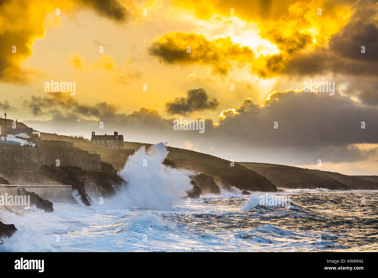 Porthleven, Cornwall, UK. 5th Jan, 2018. UK Weather. Westerly winds continue to push huge waves into Porthleven on the south west coast of Cornwall this morning at sunrise, before the winds swing round to the north east. The cliff path between Porthleven and Loe Bar is closed today due to a large cliff fall. Large waves are still causing ongoing damage. Credit: Simon Maycock/Alamy Live News Stock Photo