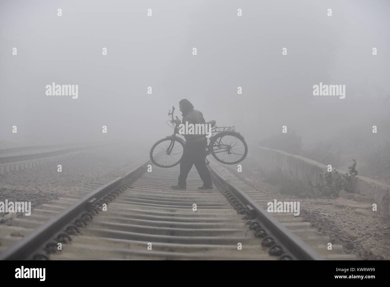 Allahabad, Uttar Pradesh, India. 5th Jan, 2018. A cyclist crosses a railway track during dense fog in Allahabad. Credit: Prabhat Kumar Verma/ZUMA Wire/Alamy Live News Stock Photo