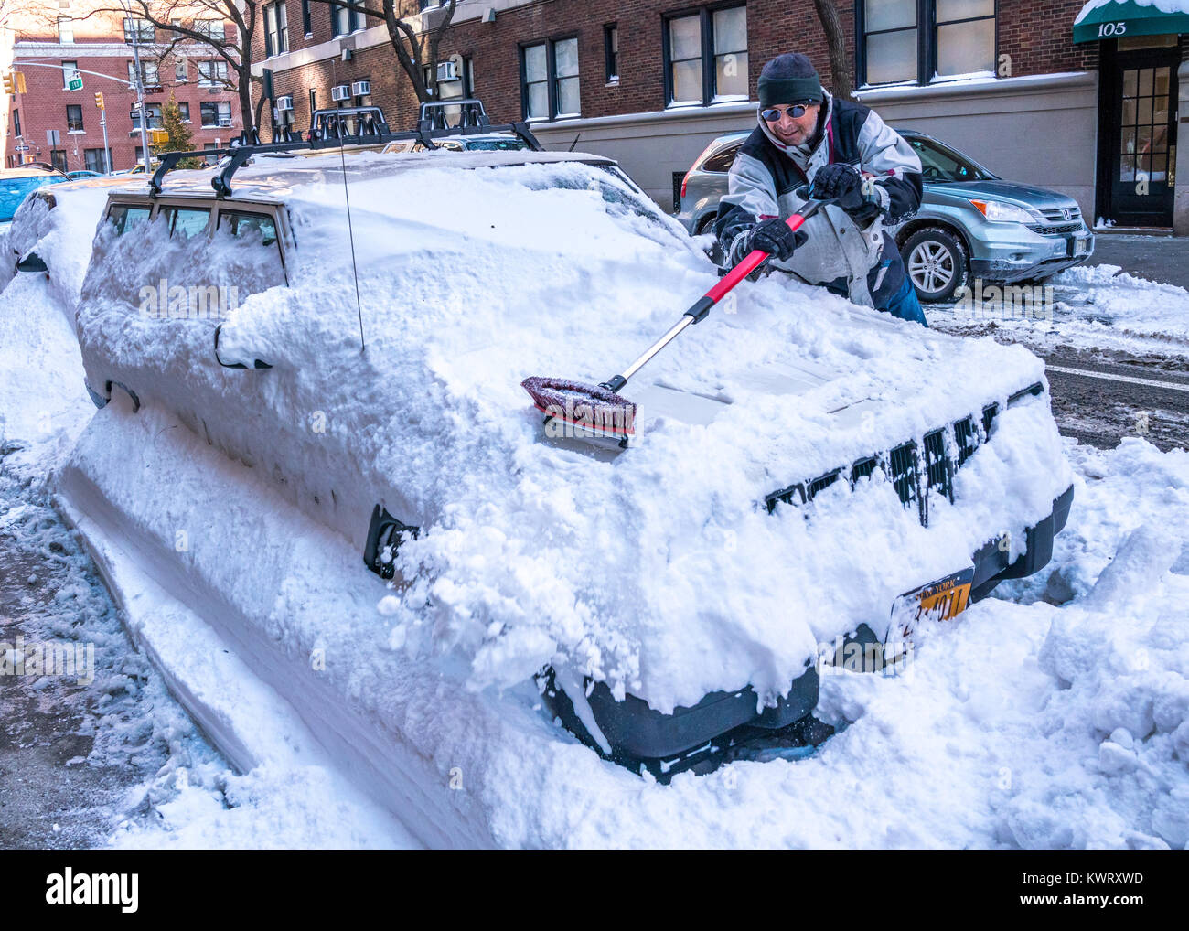 New York, USA. 5th Jan, 2018. A resident clears his snow-covered car in New York's Upper East Side after a 'bombogenesis' or 'bomb cyclone' blizzard brought record snow, bitter cold and strong winds over the city. Credit: Enrique Shore/Alamy Live News Stock Photo