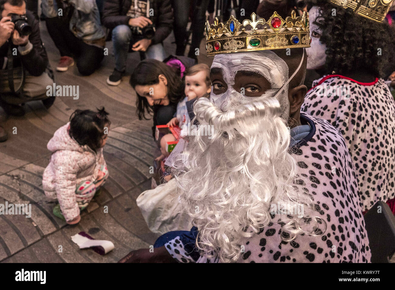 Barcelona, Catalonia, Spain. 5th Jan, 2018. The Kings street vendors seen distributing candies to children.The Three Wise Men handing out candies is a Spanish tradition since the 19th century. But these are really a very special Three Wise Men. One of them is a woman, and all three are ethically black. They are the three kings street vendors and they are the homeless people of Barcelona. Credit: SOPA/ZUMA Wire/Alamy Live News Stock Photo