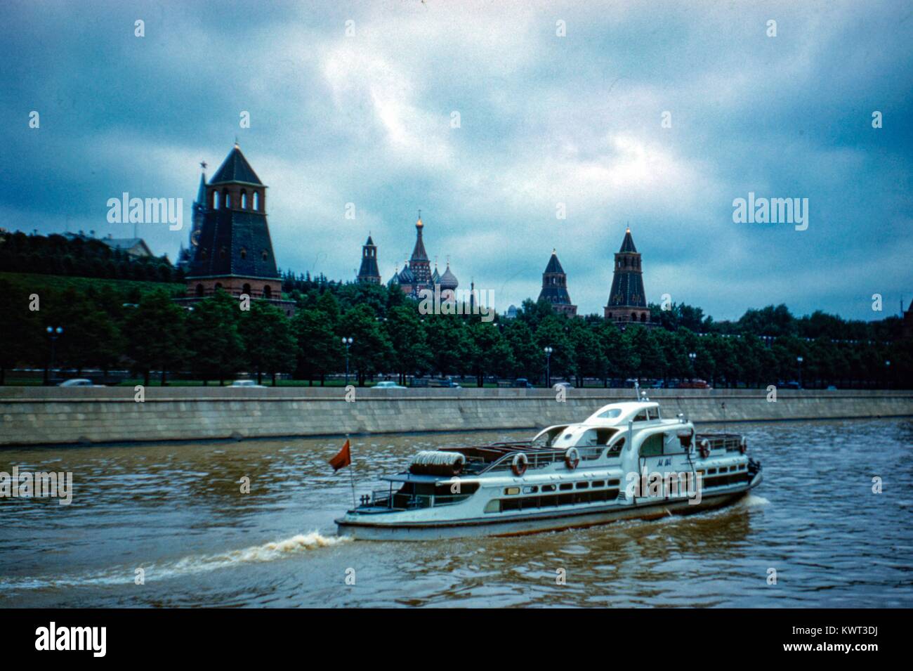 A passenger boat passes through the Moscow River, with towers of the Kremlin visible in the background, on an overcast day under a threatening sky, Moscow, Russia, August, 1959. () Stock Photo