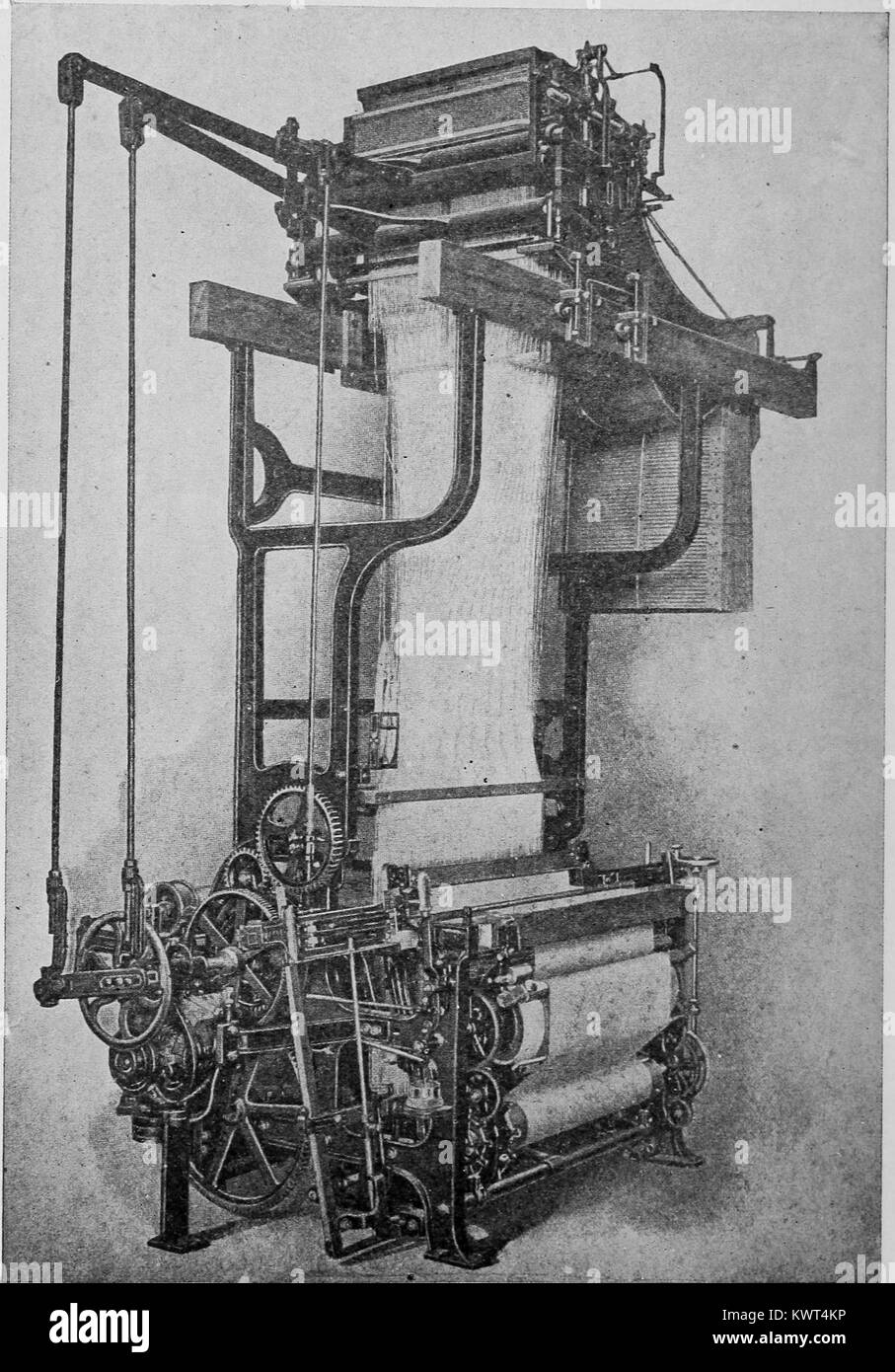 Engraved image of a Jacquard silk loom with a motor drive, and early example of industrial automation; Jacquard looms use the patterns punched on a card to automatically weave complex fabric designs, and were an inspiration for early punch card computers, 1918. Courtesy Internet Archive. Stock Photo