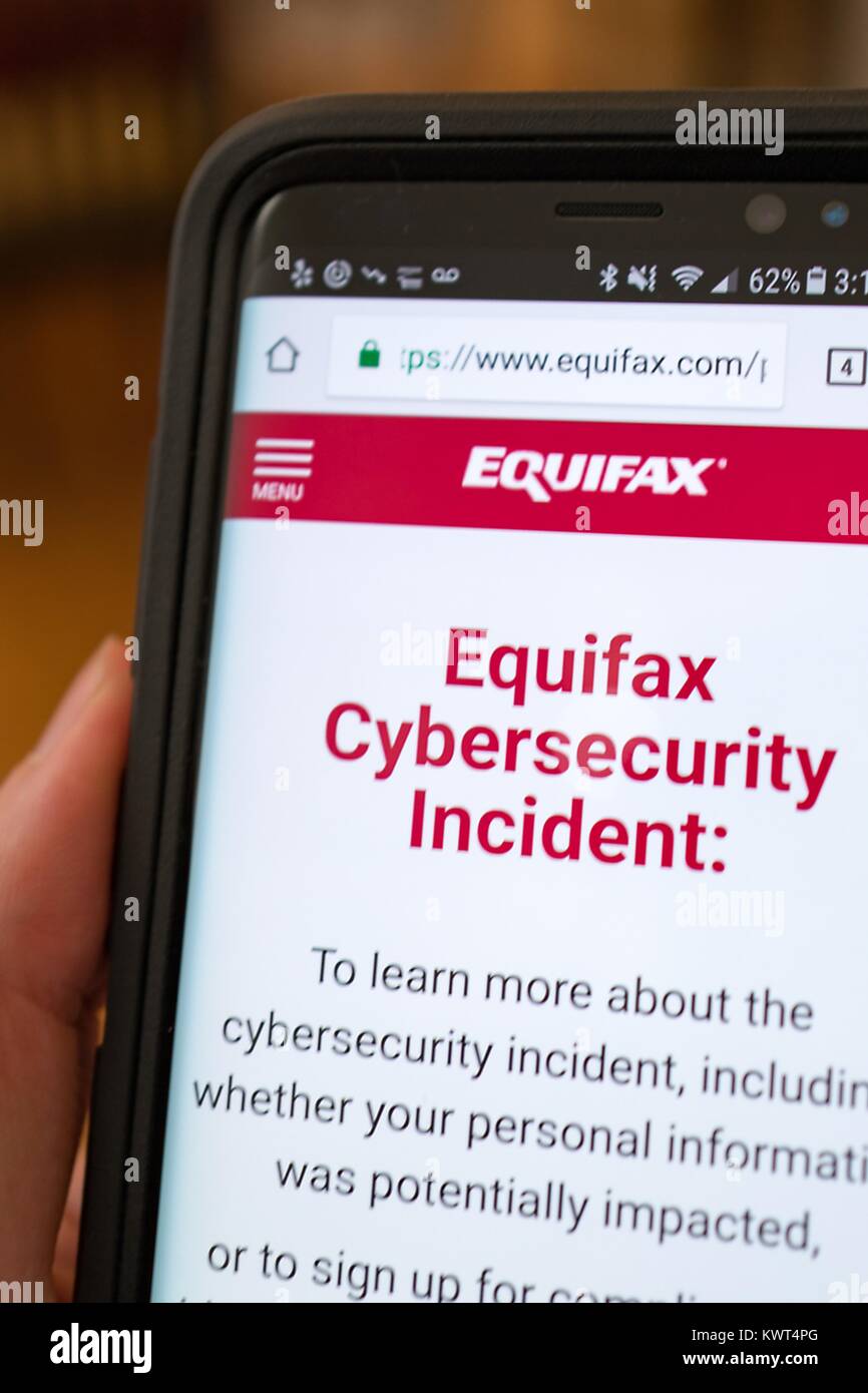 Close-up of a hand holding a cellphone open to the website of credit bureau Equifax, showing information about a 2017 cybersecurity breach in which hackers allegedly stole the personal information of millions of people, San Ramon, California, September 28, 2017. () Stock Photo