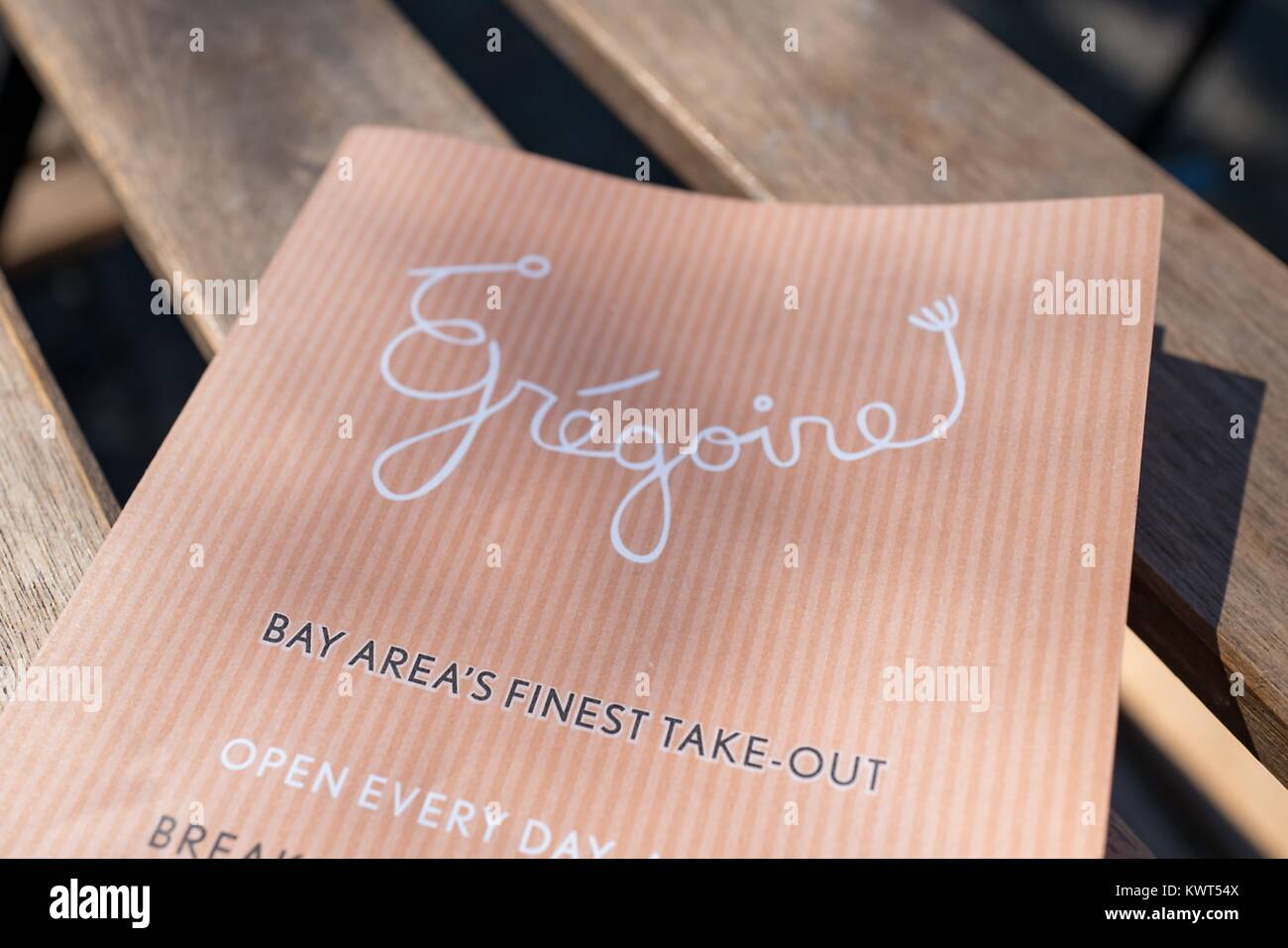 Close-up of menu for Gregoire, with tagline reading 'Bay Area's Finest Takeout', on a wooden surface in the Gourmet Ghetto (North Shattuck) neighborhood of Berkeley, California, October 6, 2017. () Stock Photo