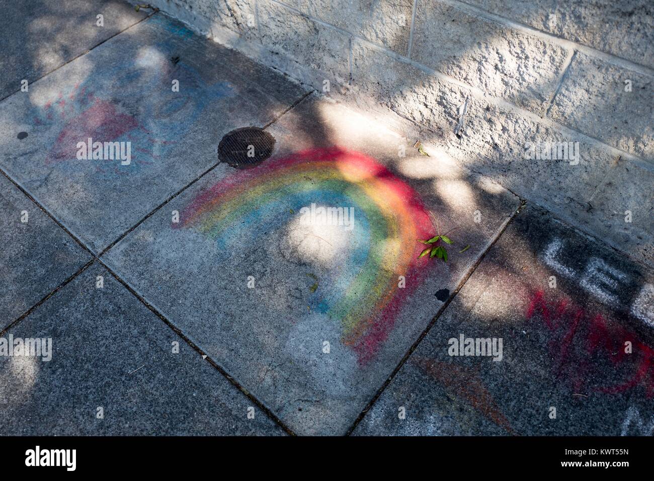 In the Gourmet Ghetto (North Shattuck) neighborhood of Berkeley, California, someone has used sidewalk chalk to draw a rainbow on the sidewalk, a symbol both of the hippie movement and of LGBT rights, October 6, 2017. () Stock Photo