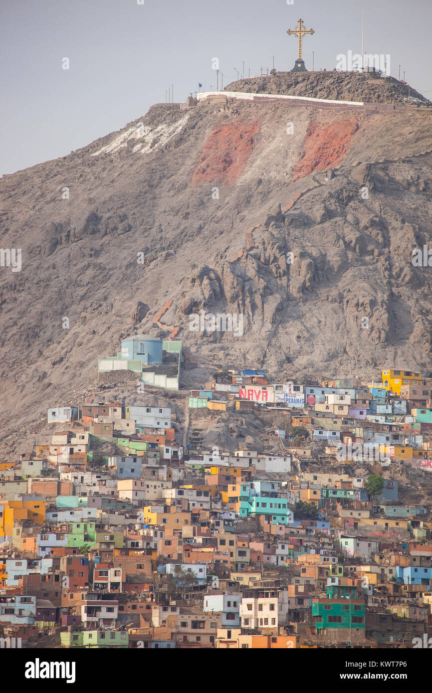 A colorful neighborhood on the outskirts of Lima, Peru. A large cross and rendition of the