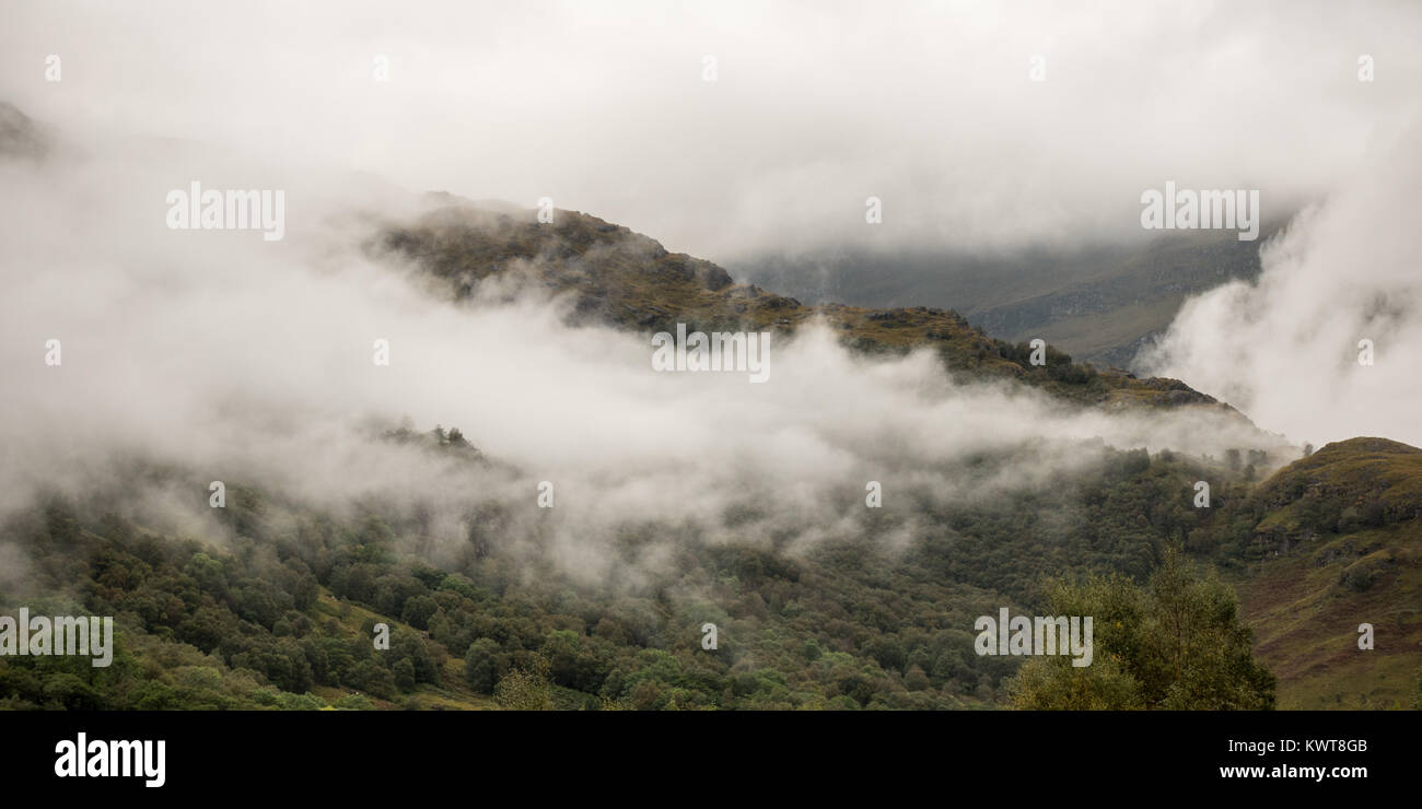 Mist rises into clouds from the slipes of Ben Nevis mountain in Glen Nevis in the West Highlands of Scotland. Stock Photo