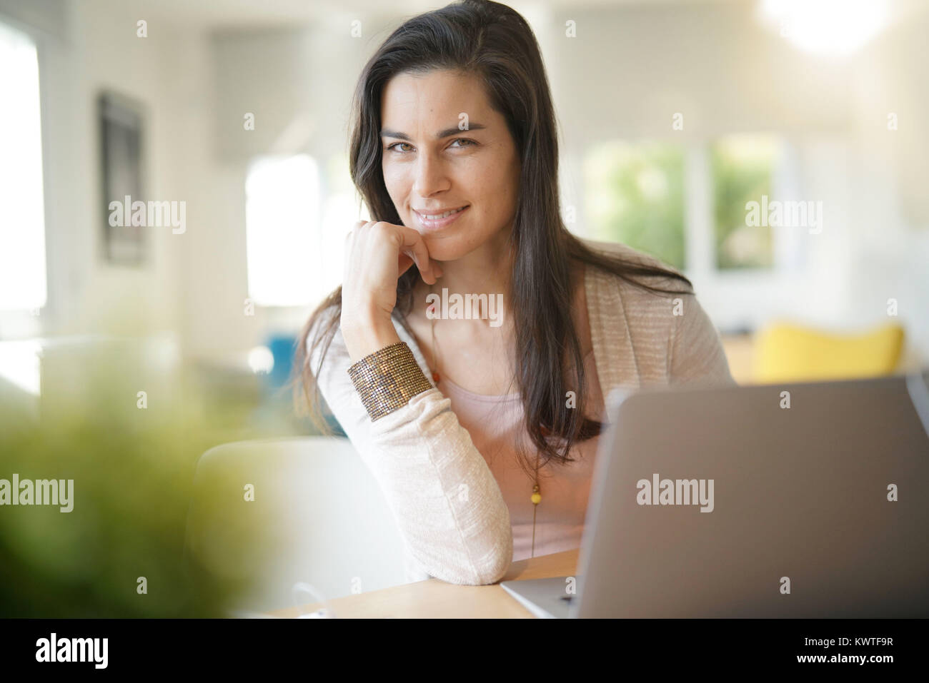 Portrait of brunette girl working on laptop computer Stock Photo - Alamy