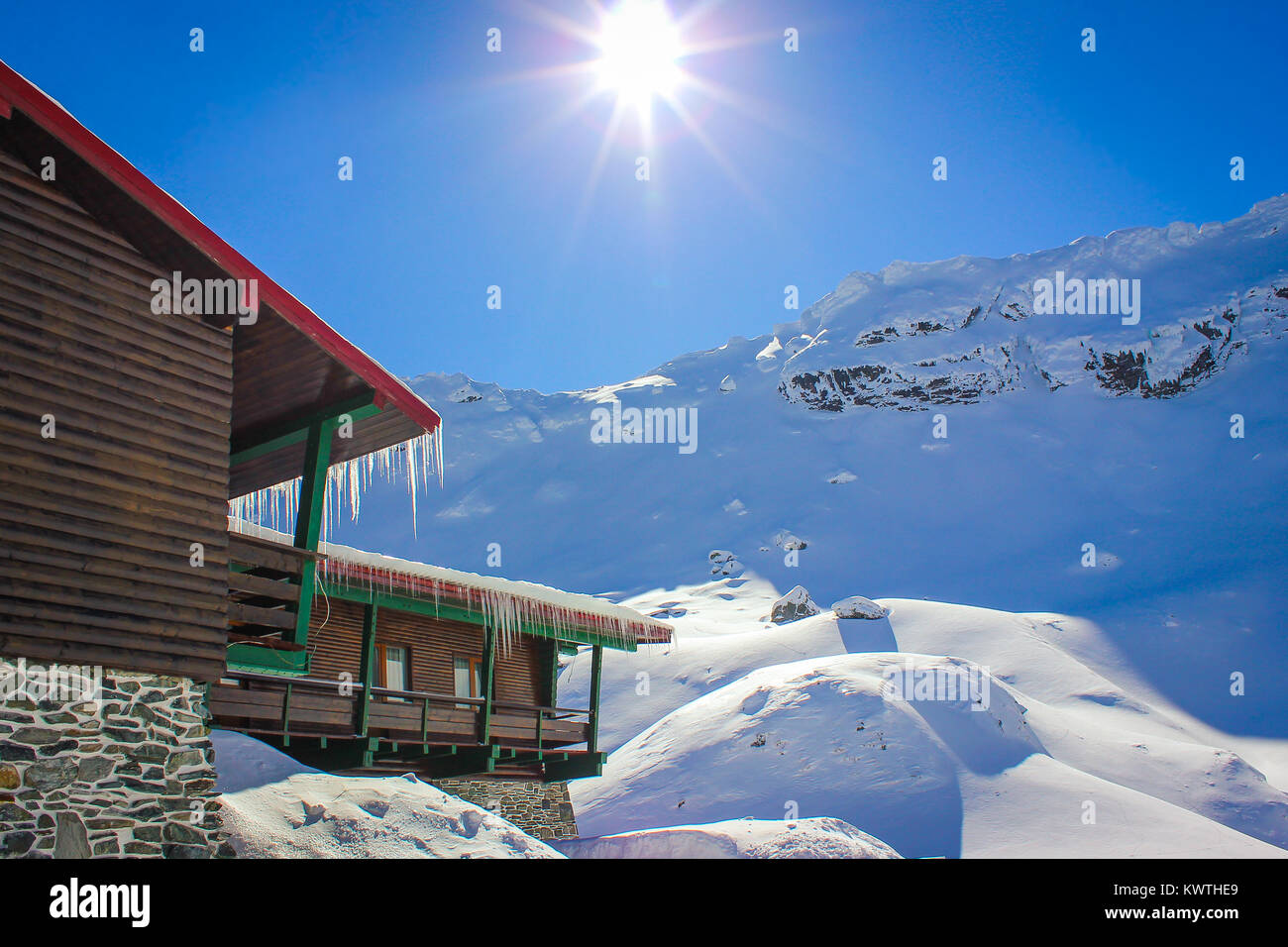 Alpine winter landscape with cabin at Balea Lake and Fagaras Mountains covered with snow in Sibiu County, Romania Stock Photo