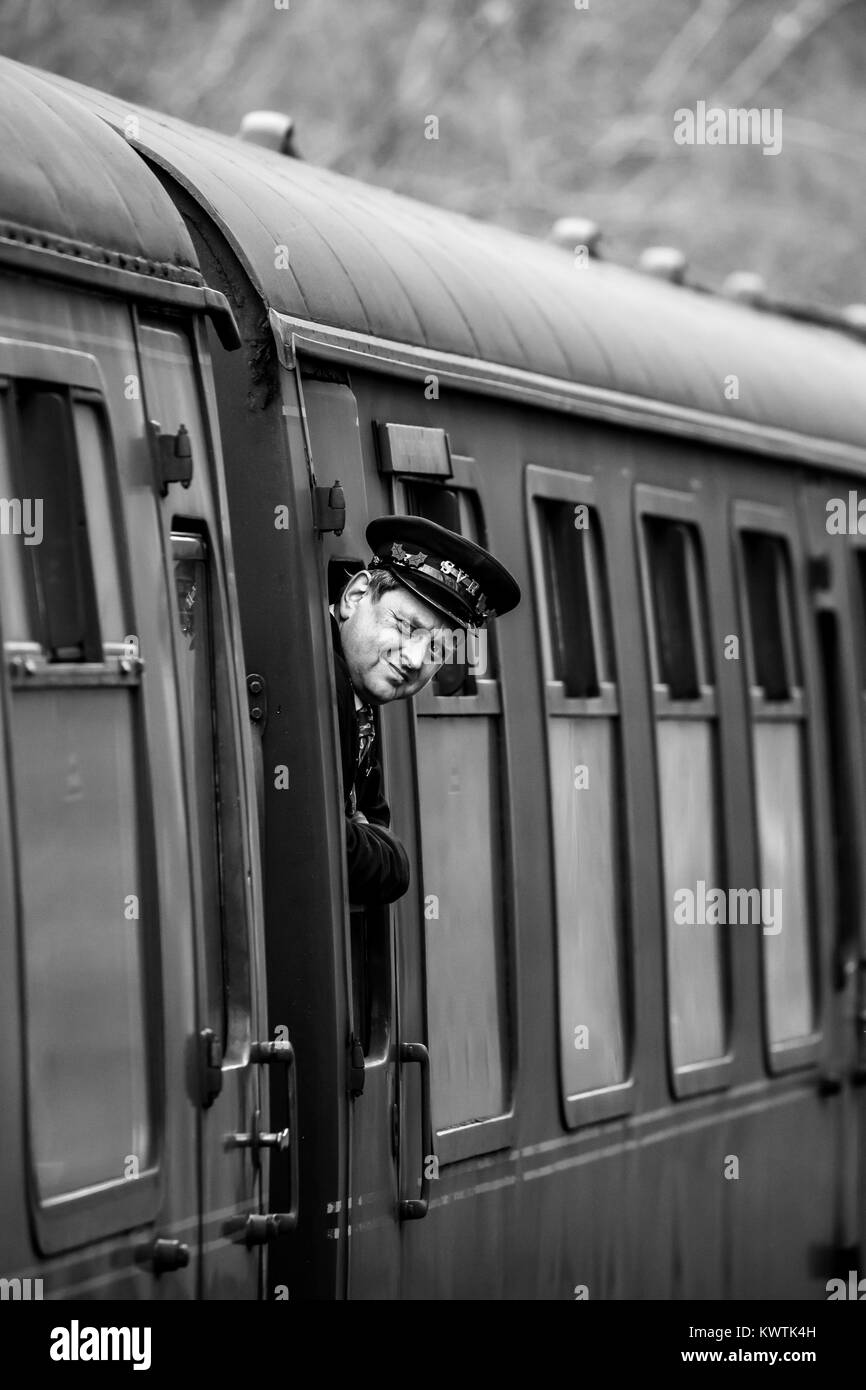 Severn Valley Railway steam locomotive stops for passengers at Alveley's Country Park Halt. Guard looks out of carriage window to check the platform. Stock Photo