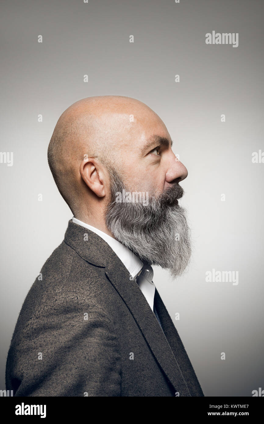 Middle-aged man with beard, studio portrait, comic profile. Stock Photo