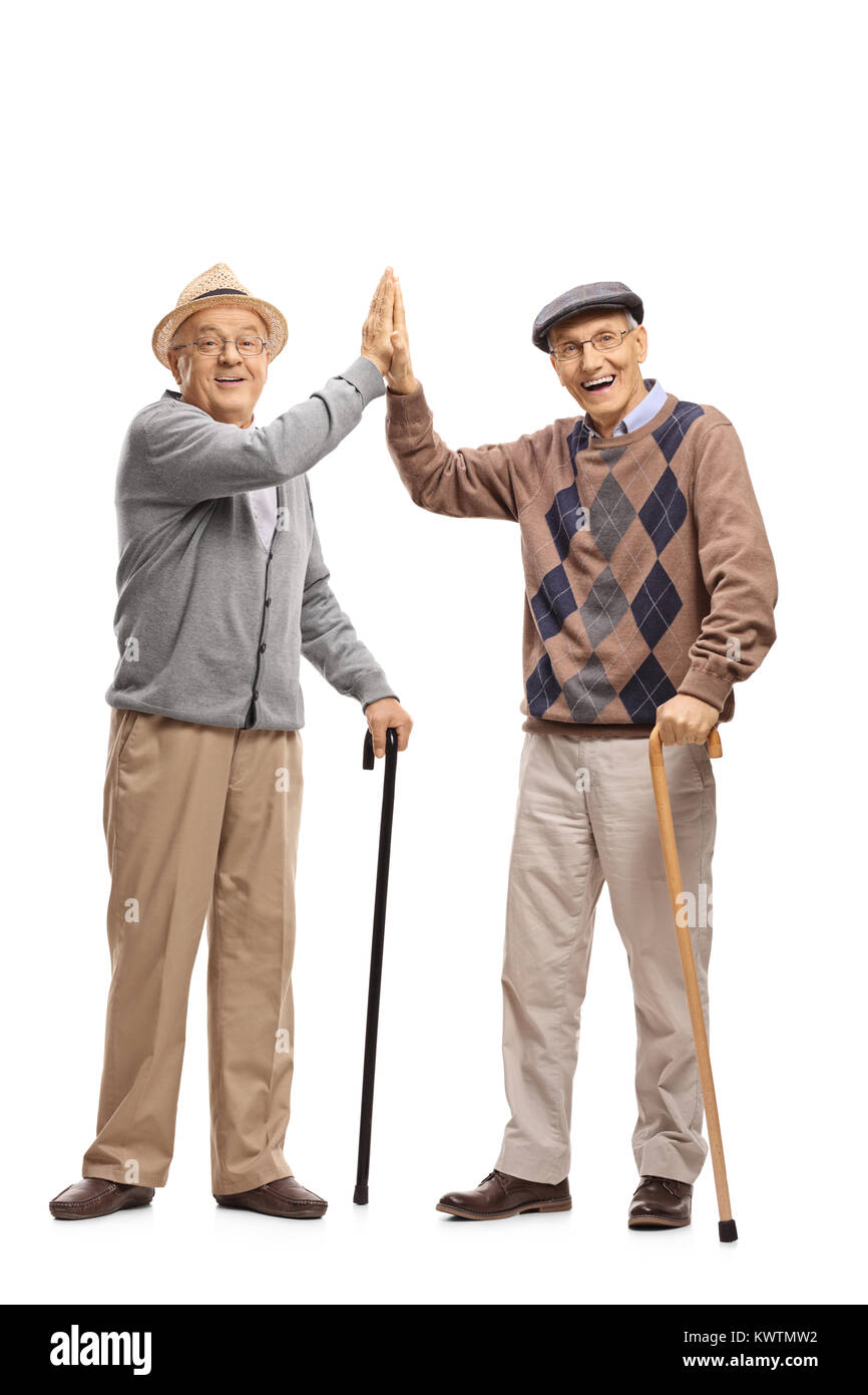 Full length portrait of seniors with canes high-fiving each other isolated on white background Stock Photo