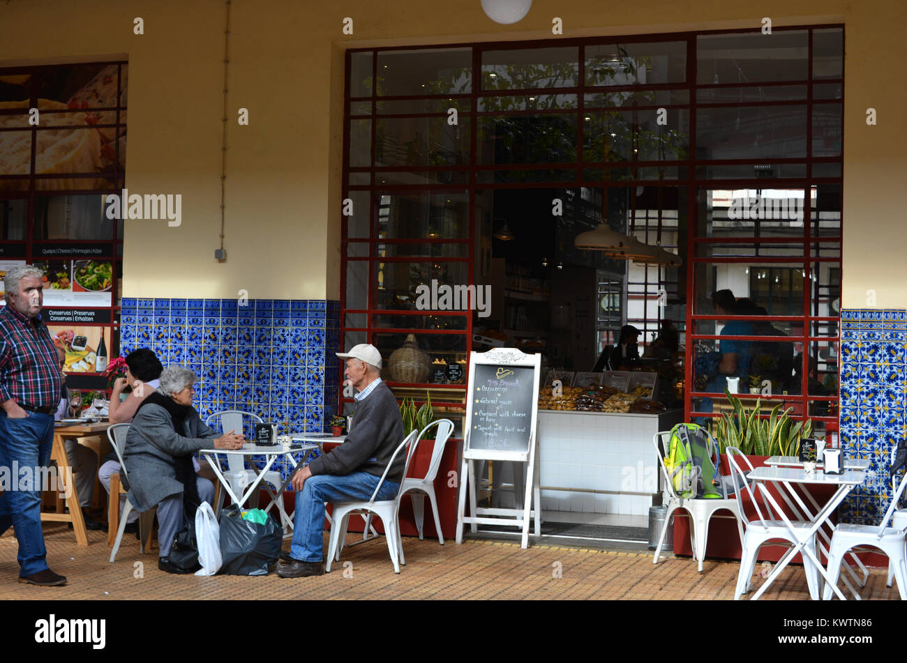 Senior couple seated at an outdoor table of a restaurant in the Mercado dos Lavradores, Funchal, Madeira, Portugal. Stock Photo