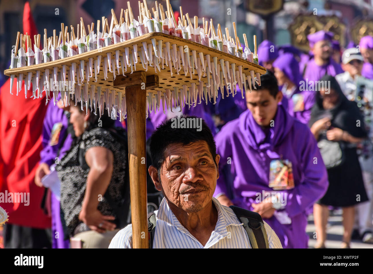 Antigua, Guatemala -  March 19, 2017: Candy seller follows Lent procession in colonial town with most famous Holy Week celebrations in Latin America. Stock Photo