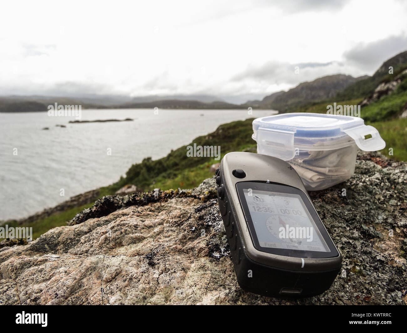 geocaching in scotland with gps device and cache container Stock Photo