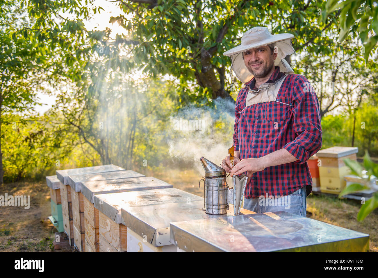 Beekeeper preparing smoke pot to check his beehives Stock Photo