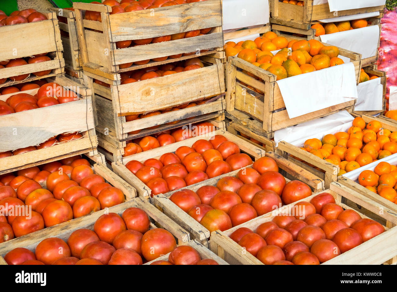 Tomatoes and tangerines in wooden boxes for sale at a market in Valparaiso, Chile Stock Photo