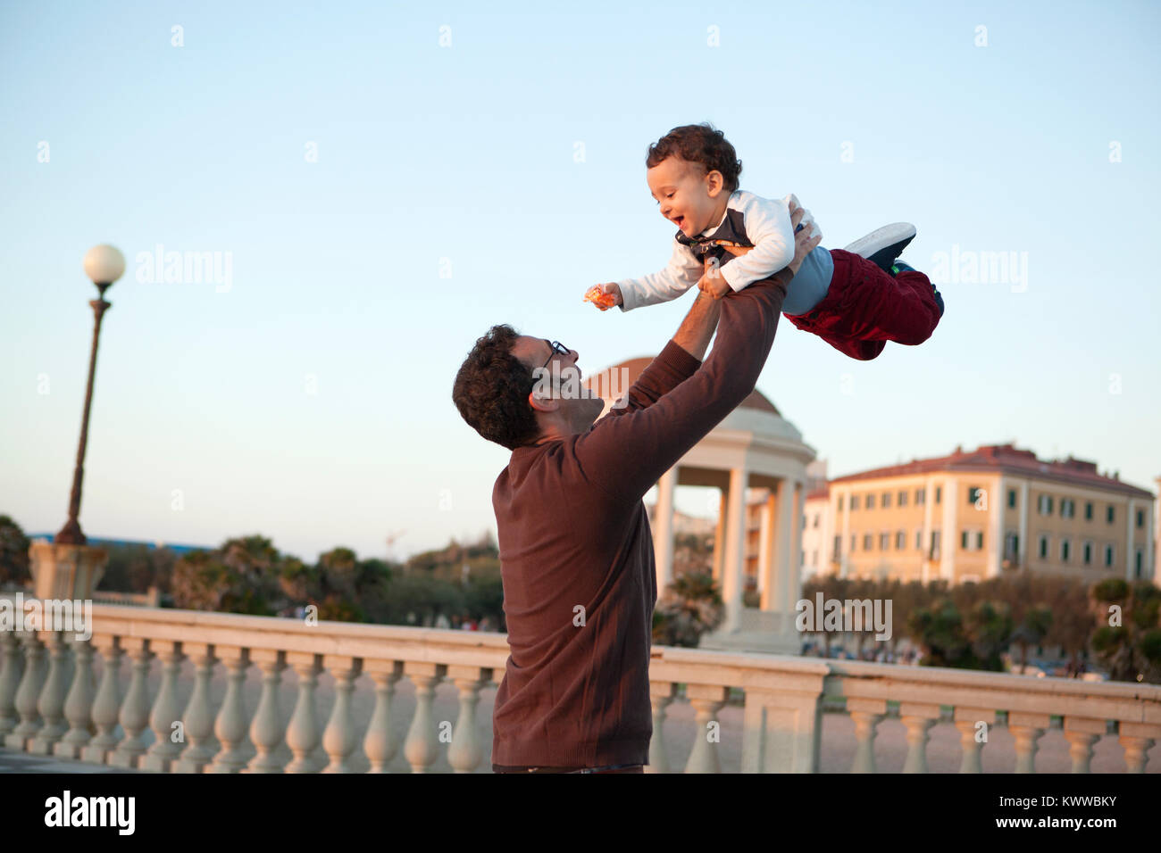 A young father and his male child on the seafront at Livorno, Italy Stock Photo