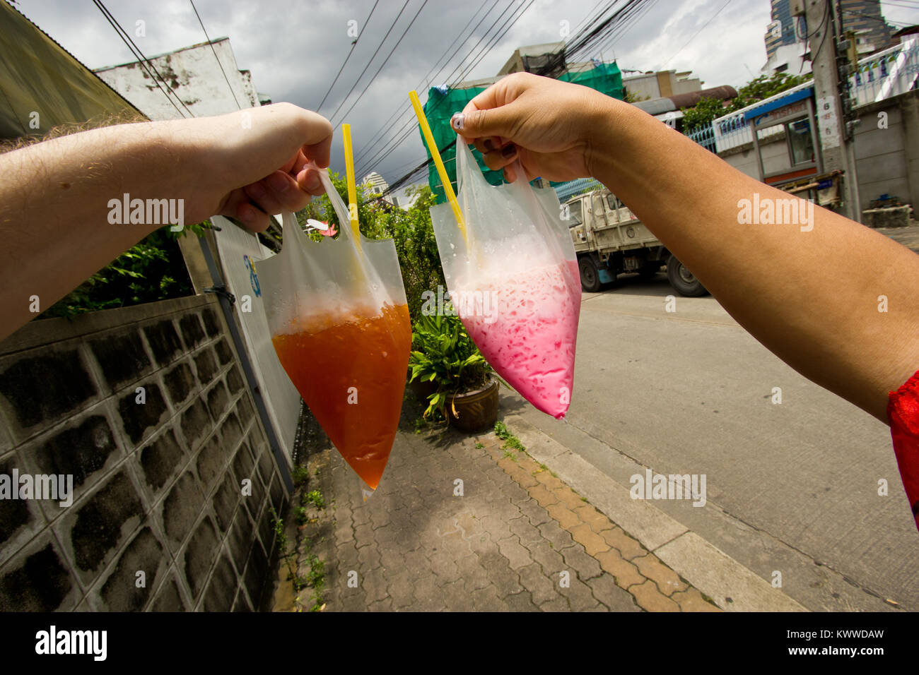 Tourists with soft drinks in plastic bags in Bangkok, Thailand Stock Photo