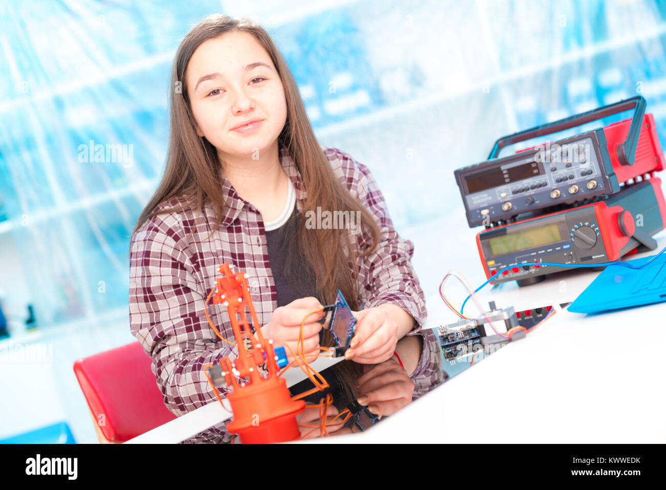 Schoolgirl in laboratory robots debug microcontroller Stock Photo
